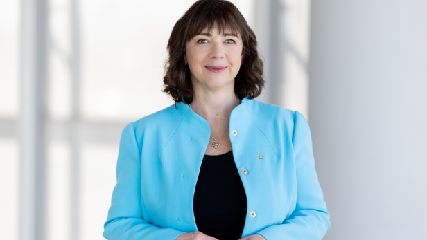 Eine brünette Frau in einem blauen Blazer 