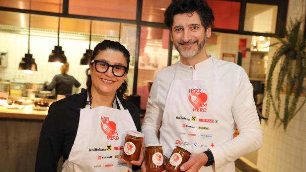 Parvin Razavi und Paul Ivic mit Schürzen und Marmeladengläsern in den Händen