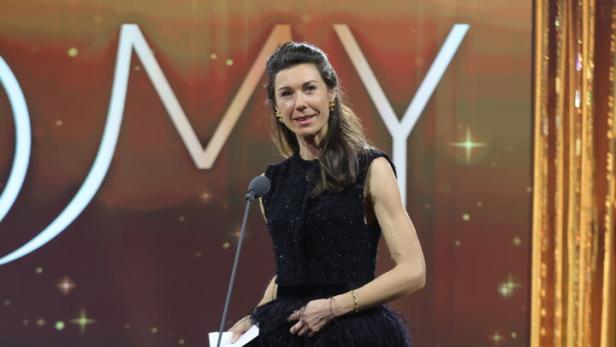 Raffaela Schaidreiter in einem schwarzen Kleid steht an einem Mikrofon auf einer Bühne.