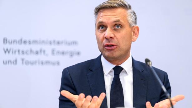 Hattmannsdorfer gestikuliert vor dem Schriftzug "Bundesministerium Wirtschaft, Energie und Tourismus".
