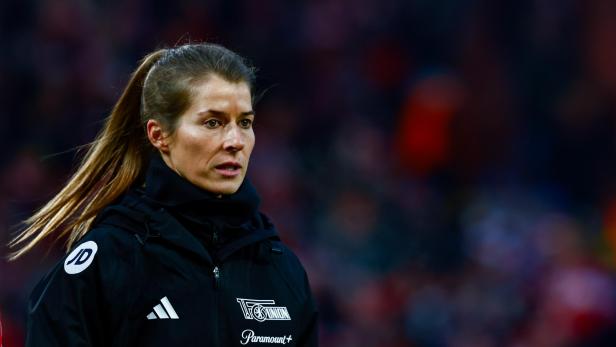 Eine Frau mit Pferdeschwanz trägt eine schwarze Jacke mit dem Logo von FC Union Berlin.