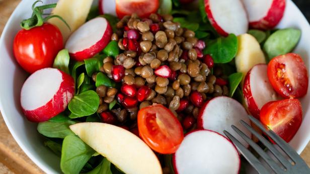 Eine Schüssel mit Salat, Gemüse und Linsen.