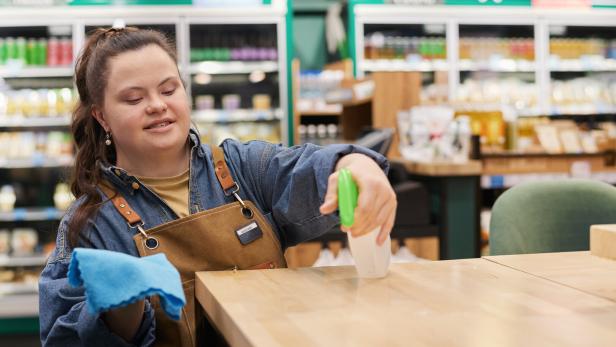 Mädchen mit Behinderung bei der Arbeit in einem Cafe