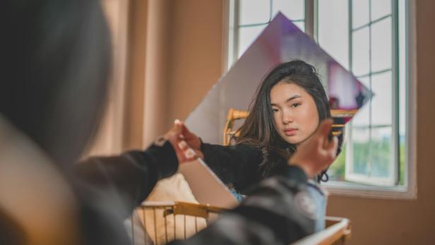 Frau sieht sich in den Spiegel 