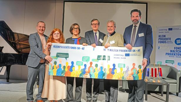 Sechs Personen halten ein Plakat zum Kleinprojektefonds Slowakei-Österreich auf einer Bühne.