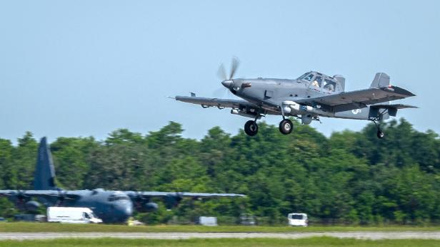 Ein graues Propeller-Flugzeug setzt zur Landung an