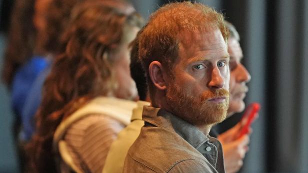 Prinz Harry blickt aufmerksam, mit Bart und rötlichem Haar, in die Ferne.