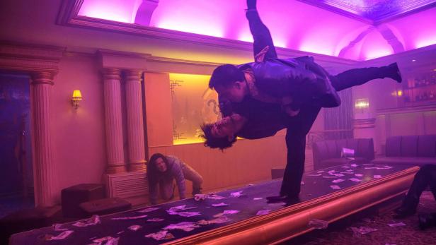 Martial-Arts-Kampf zweier Männer in einem Nachtclub, der in violettes Licht getaucht ist