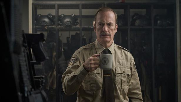 Bob Odenkirk als Sheriff mit Bierglas.