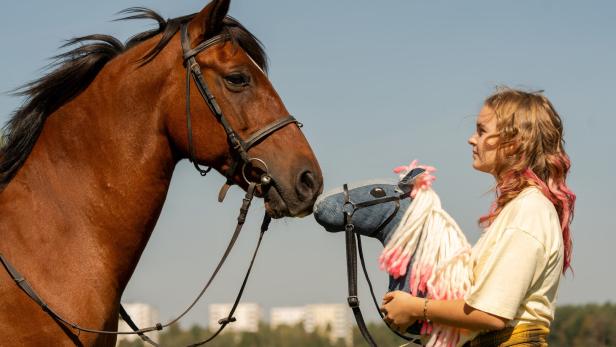 Marion Debaille mit einem Pferd und einem Steckenpferd.