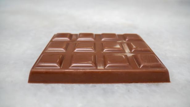 Eine Tafel Milchschokolade von Celleste Bio, hergestellt mit im Labor gezüchteter Kakaobutter, liegt auf einer hellen Oberfläche.