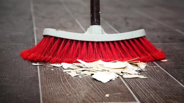 Sweeping the wooden floor with a broom