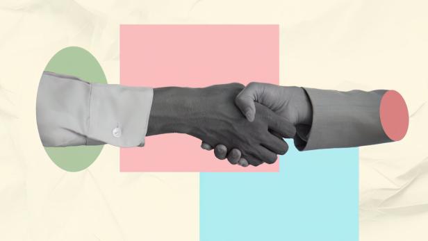 Professional handshake between a light skinned woman and a dark-skinned man in a corporate setting, fostering collaboration