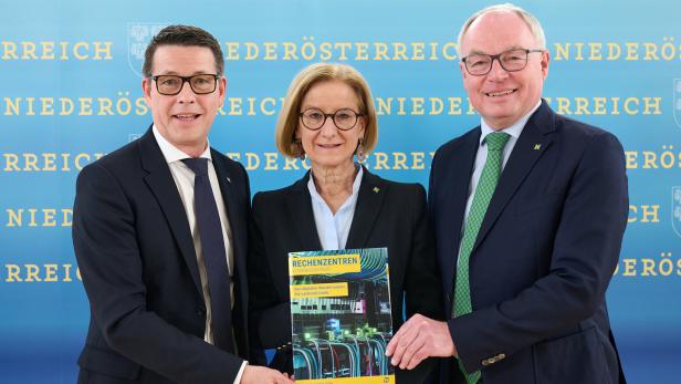 Drei Personen präsentieren eine Broschüre über Rechenzentren in Niederösterreich vor blauem Hintergrund.