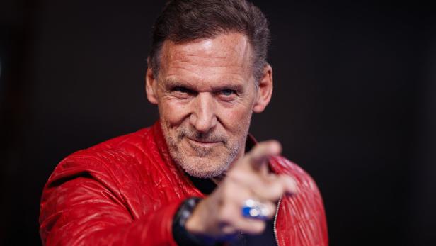 Ralf Möller in roter Lederjacke zeigt mit dem Finger direkt auf den Betrachter.