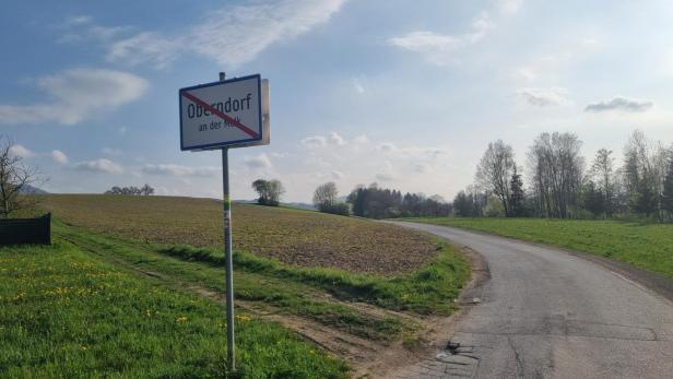 Ortsschild von Oberndorf an der Melk am Rand eines Feldes mit angrenzender Landstraße.