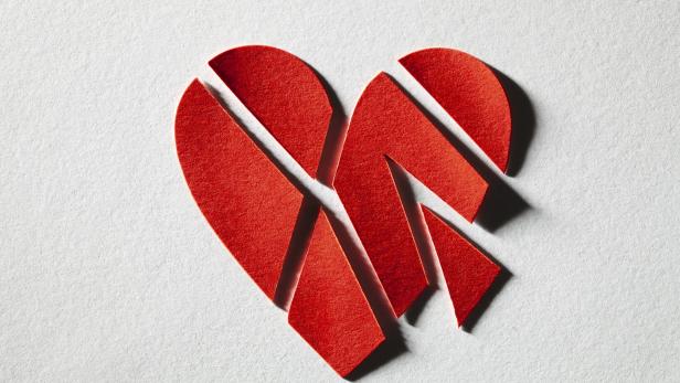 Ein Herz aus Papier ist in mehrere Stücke geschnitten. 