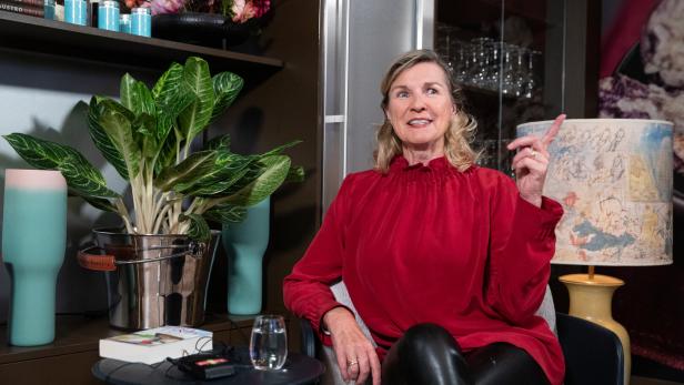 Hera Lind sitzt und gestikuliert beim Sprechen.