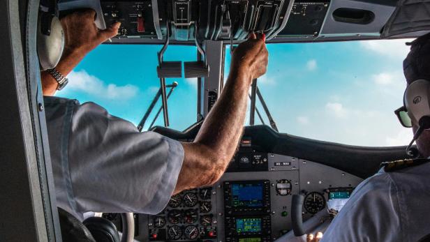 Piloten sitzen im Cockpit bei blauem Himmel