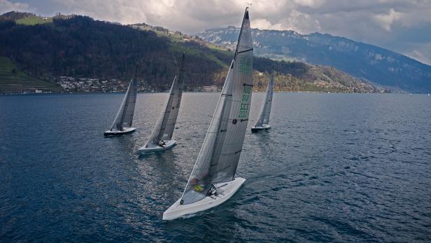 Vier Segelboote auf dem Wasser an einem bewölkten Tag.
