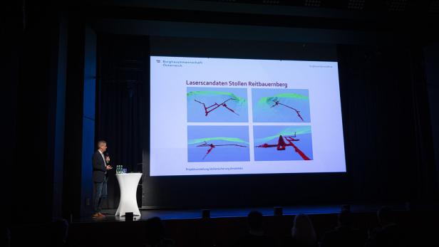 Mann präsentiert Laserscans der Stollenanlagen Reitbauernberg auf einer Bühne vor Publikum.