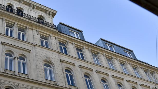 Die Fassade eines Altbaus mit vielen Fenstern unter blauem Himmel.