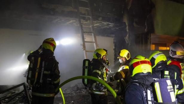 Feuerwehrleute in einer ausgebrannten Wohnung