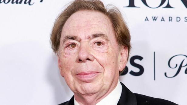 Andrew Lloyd Webber hält eine Tony Award Trophäe in einem schwarzen Smoking.