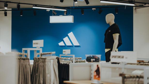 Innenansicht einer adidas Filiale, zeigt das markante Logo und eine ansprechende Produktpräsentation.