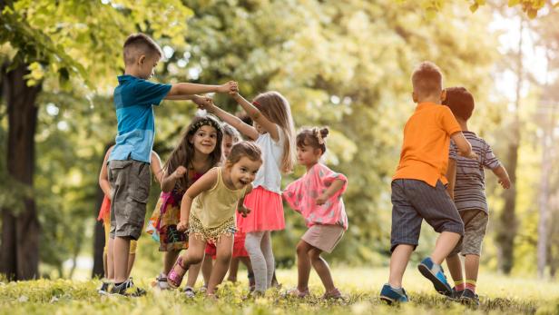 Group of small kids having fun while playing in nature.
