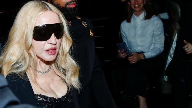 Madonna trägt übergroße Sonnenbrille und wird von einem Mann begleitet.
