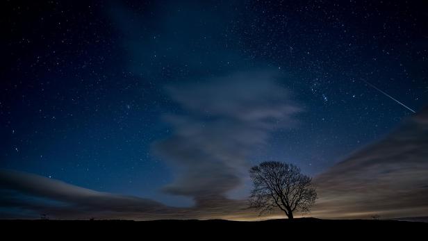 Sternschnuppe am Nachthimmel voller Sterne