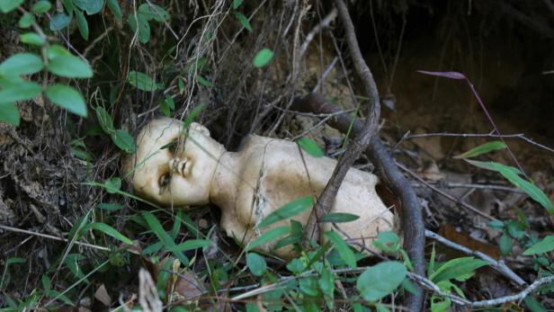 Alte Puppe, die im Unterholz liegt