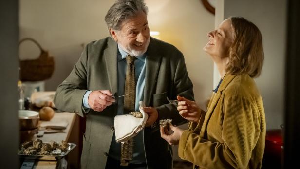  Jodie Foster und Daniel Auteuil stehen in der Küche und lachen.
