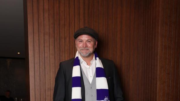 Thomas Stipsits mit einem weiß-violett-gestreiften Schal