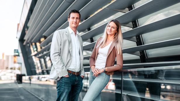 Ein Mann und eine Frau lehnen an einer Fassade