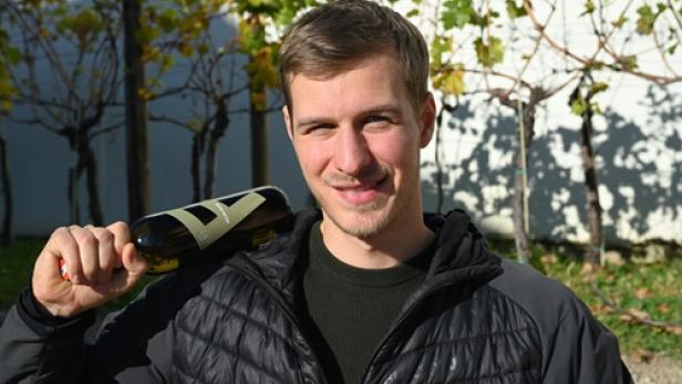 Ein Winzer mit Flasche in der Hand