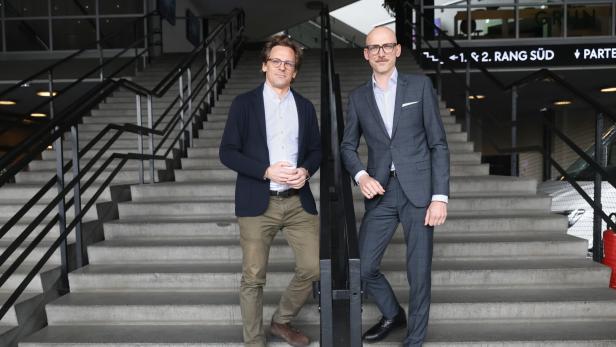 Thomas Waldner und Matthäus Zelenka mit Brille stehen auf einer Treppe mit schwarzem Geländer.