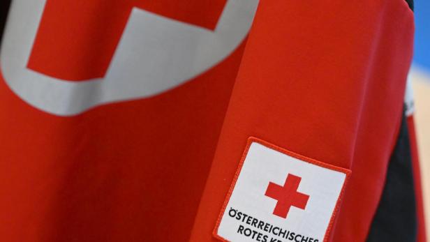 Rotes Kreuz Abzeichen und Notfalldienst Salzburg Aufnäher auf roter Jacke.