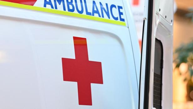 Ein Rettungswagen des Österreichischen Roten Kreuzes mit geöffnetem Heck steht im Freien.