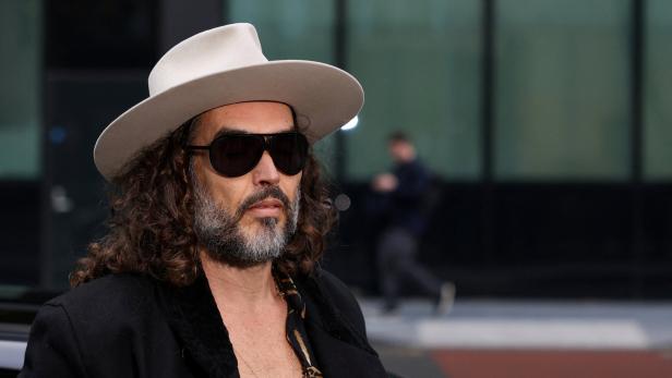 Russell Brand trägt Hut und Sonnenbrille.