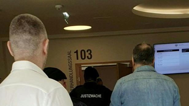 Zwei mutmaßliche Mitglieder des Kavač-Clans werden von Justizwachebeamten in Handschellen zum Verhandlungssaal im Wiener Landesgericht geführt.