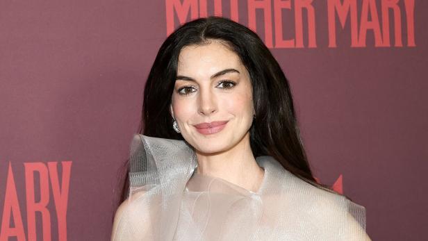Anne Hathaway vor rotem Hintergrund mit dem Schriftzug "Mother Mary".