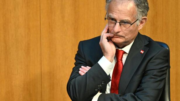 Markus Marterbauer sitzt nachdenklich da, die Hand am Kinn.