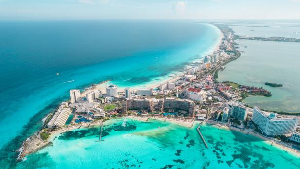 Aerial panoramic view of Cancun beach and city hotel zone in Mexico. Caribbean coast landscape of Mexican resort with beach Playa Caracol and Kukulcan road. Riviera Maya in Quintana roo region on Yucatan Peninsula