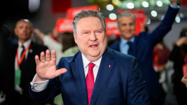 Michael Ludwig in einem blauen Anzug mit roter Krawatte winkt in einer Menschenmenge.