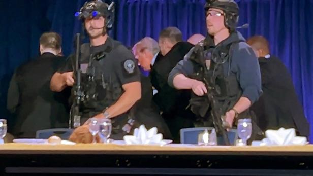 U.S. President Donald Trump is escorted out of the White House Correspondents' Association (WHCA) dinner in Washington