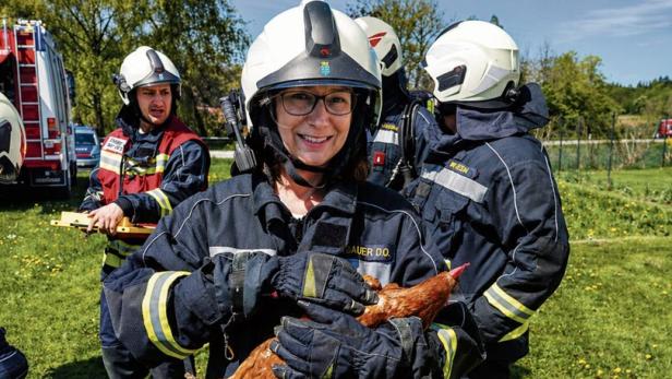Gerettete Henne in den Armen einer Feuerwehrfrau