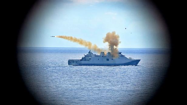 Eine Fregatte auf dem Meer startet eine Rakete, die nach links fliegt