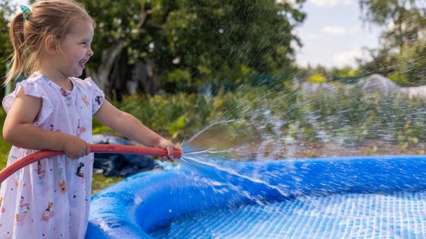 Ein Mädchen befüllt einen Pool.